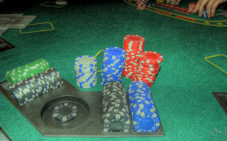 Kartu dan chip poker di atas meja turnamen kompetitif
